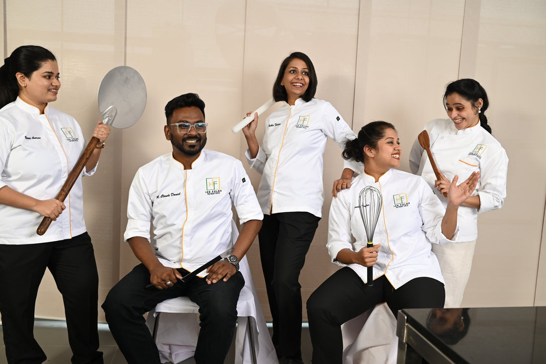 A group of five chefs from a Hyderabad pastry school smiles for a photo, showcasing a large spatula they are holding.