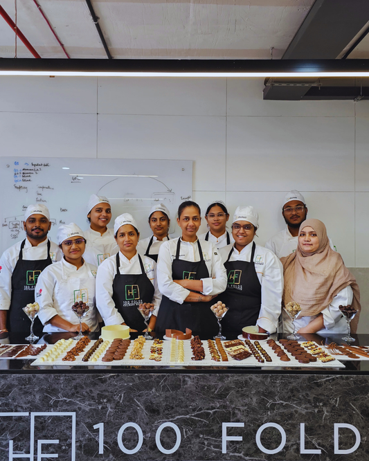 Students enrolled in a baking diploma in Hyderabad presenting professional handmade chocolates and pastry creations at 100 Folds Culinary Guild.