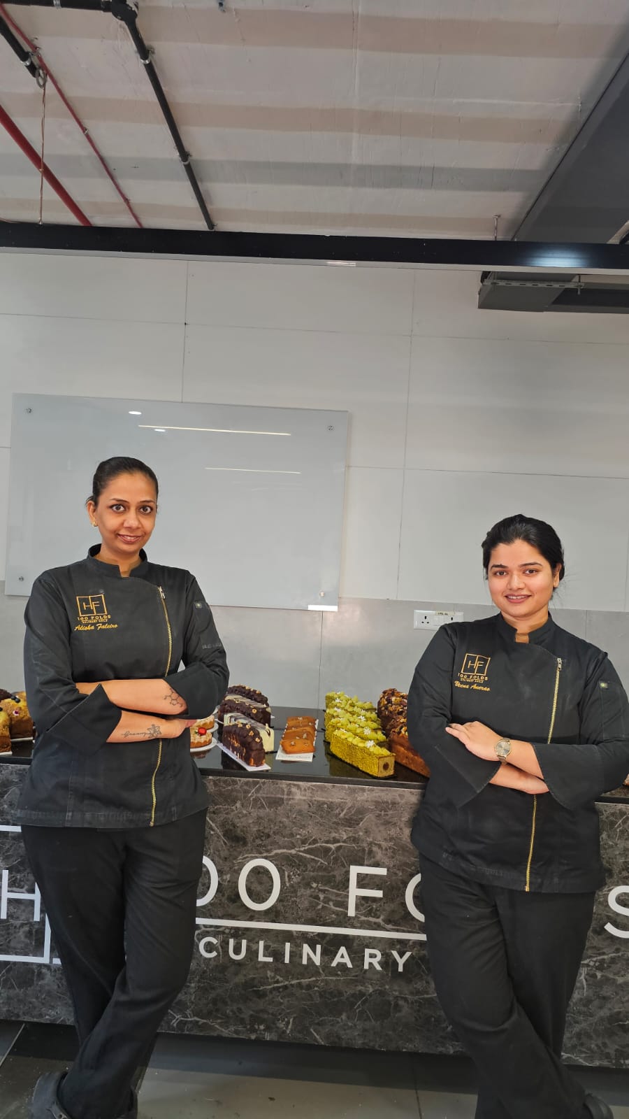 Professional pastry chefs showcasing baked products at a culinary academy, highlighting career opportunities in baking and pastry arts