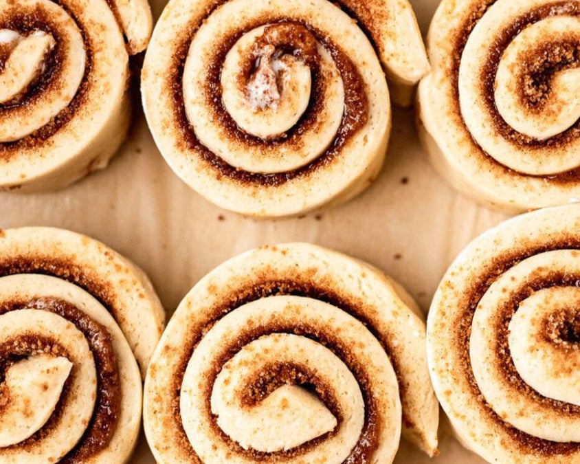 Row of cinnamon rolls on a baking sheet