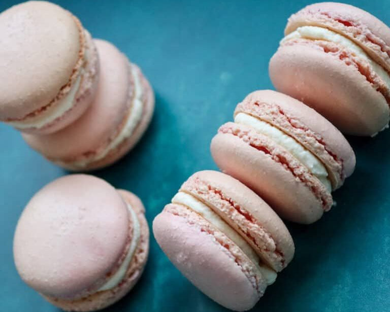 Pink macarons on a blue surface